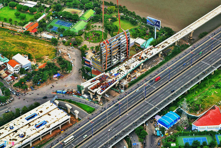 Chiếc cẩu đưa vật liệu lên đỉnh tháp, phía dưới là hình ảnh xe cộ di chuyển lên xuống cầu Sài Gòn trông nhỏ bé.