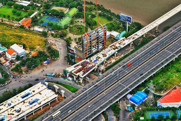 Chiếc cẩu đưa vật liệu lên đỉnh tháp, phía dưới là hình ảnh xe cộ di chuyển lên xuống cầu Sài Gòn trông nhỏ bé.