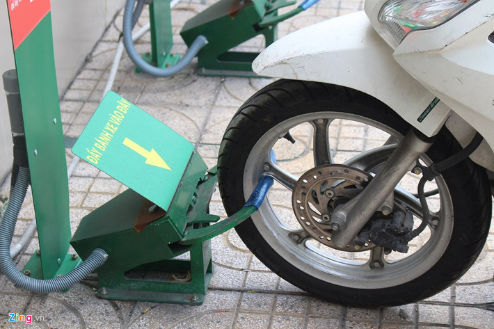 Quy trình này bắt đầu bằng việc khách tự cho bánh xe trước vào "ngàm" mở sẵn của robot. Sau khi bánh chạm mạnh vào bên trong, "ngàm" này sẽ tự động khép và khóa chặt lại.