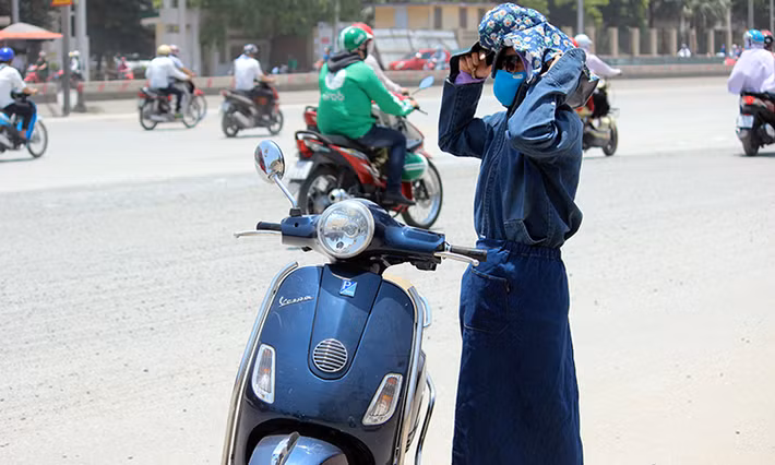 Nắng nóng gay gắt khiến nhiều người dân Hà Nội điều khiển xe máy đi ngoài đường phải "ngụy trang" như...ninja.