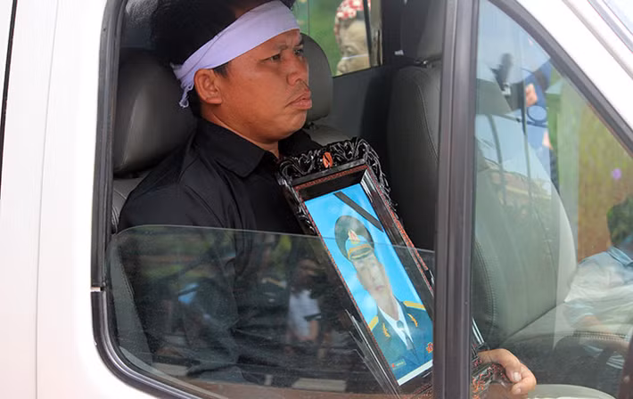 Người thân lặng lẽ ôm di ảnh Đại tá Phạm Giang Nam.