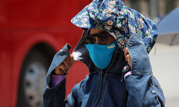 Người phụ nữ mặc đồ che nắng kín người, chỉ để lộ đôi mắt.