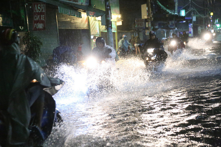 Nhiều người khác liều mình dầm mưa, lội nước vì mưa càng lớn giữa đêm khuya.