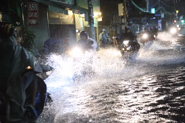 Nhiều người khác liều mình dầm mưa, lội nước vì mưa càng lớn giữa đêm khuya.