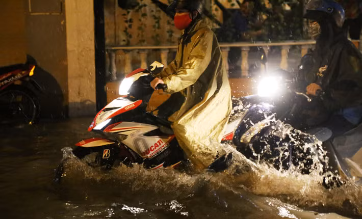 Nước ngập lút cả nửa bánh xe máy.