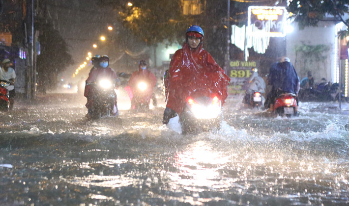 Nước ngập lút cả bánh xe khiến người dân "lóp ngóp" lội nước về nhà.