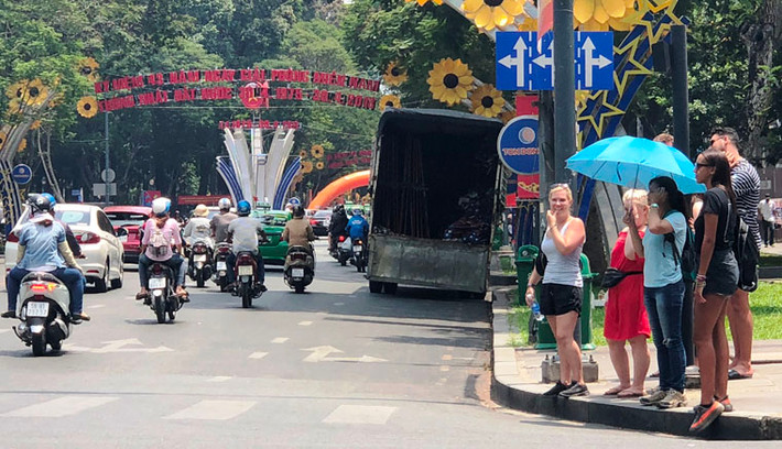 Mặc cho nắng nóng đầu hè giữa trưa ở trung tâm Sài Gòn, rất đông du khách vẫn đi lại trên đường để hòa cùng niềm vui với người dân trong ngày hội non sông.