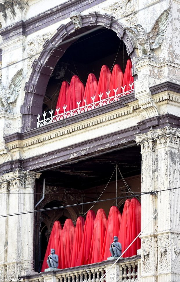 Những "người mẫu" chỉ khoác trên người duy nhất một tấm vải mỏng màu đỏ. Ảnh: APPImages