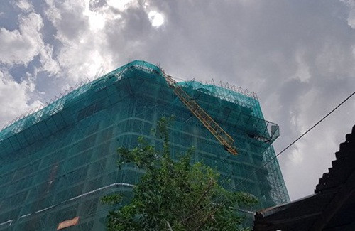 Sợi dây cáp từ cần cẩu đứt, quật vào mái nhà dân. Một số hộ gần đó phải di tản, không dám ngủ trong nhà. Ảnh: Infonet.