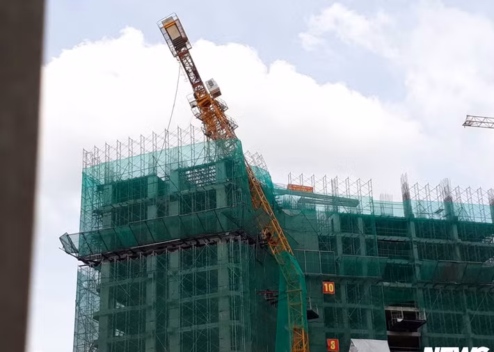 Sự việc xảy ra vào chiều 5/6. Sau tiếng ầm mạnh, người dân thấy chiếc cần cẩu cao khoảng 50m của công trình nằm lơ lửng trên tòa nhà 13 tầng đang xây bị gãy. Ảnh: VTCnews.