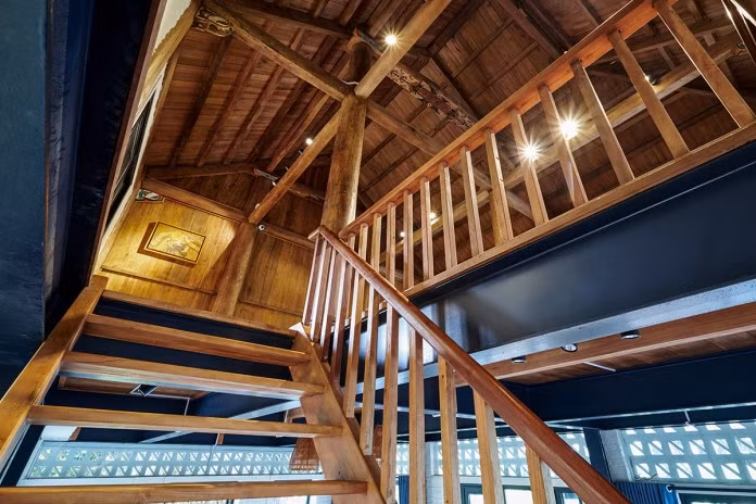 Cầu thang vốn được đặt ngoài nhà được chuyển vào giữa nhà, khéo xếp gọn bên tường.