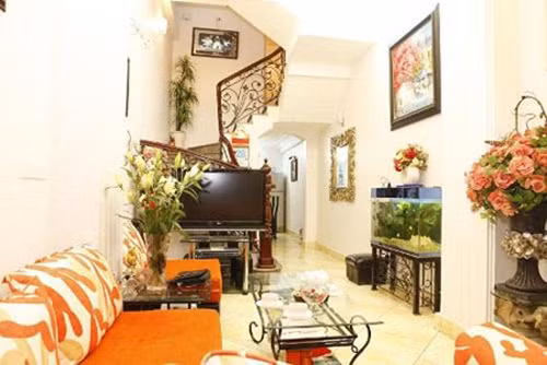 Phòng khách nổi bật với bộ sofa màu cam. Ảnh: Khám phá.