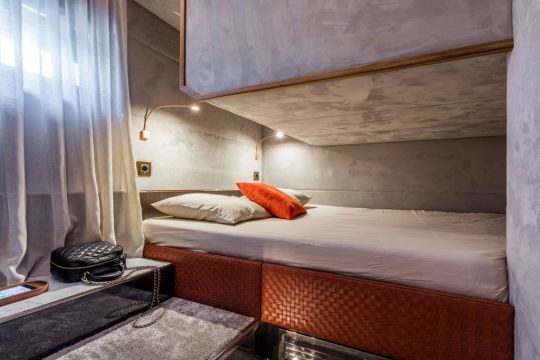 Phòng ngủ kín đáo có khung giường bọc da dệt.