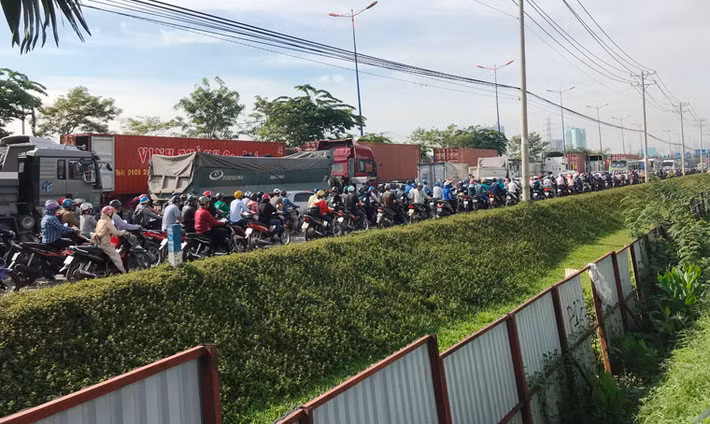 Dòng xe máy, ô tô, xe tải, xe buýt, container... xếp hàng dài nhiều km ở cả 2 hướng trên XLHN vì kẹt xe.