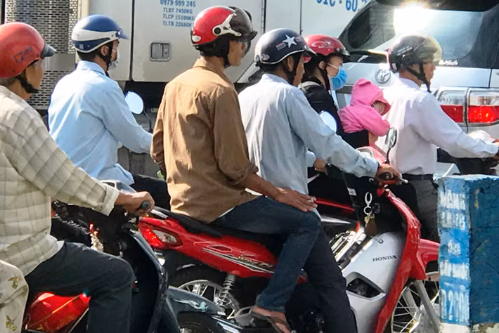 Một đứa trẻ mệt mỏi trên xe của ba mẹ giữa vòng vây kẹt xe kinh hoàng.