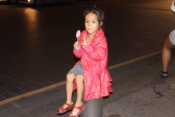 Một em bé bên vỉa hè phố đi bộ Nguyễn Huệ