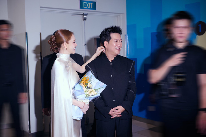 Cô lựa chọn chiếc đầm cúp ngực phom bút chì dài chạm đất, kết hợp lớp cape voan mỏng phủ bên ngoài tạo điểm nhấn mềm mại. Phần thân váy ôm vừa vặn giúp bà xã Trường Giang khoe bờ vai thanh mảnh cùng vòng eo thon thả.