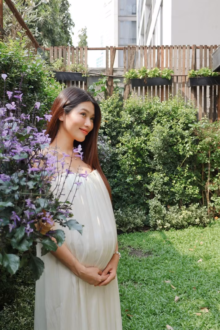 Không lựa chọn phong cách gợi cảm hay hở hang, Quỳnh Châu ưu tiên những thiết kế dài, chất liệu mềm mại, ôm sát cơ thể. Chính sự tinh tế này giúp tôn lên đường cong tự nhiên của người phụ nữ khi mang thai, đồng thời mang lại vẻ đẹp nhẹ nhàng, sang trọng.