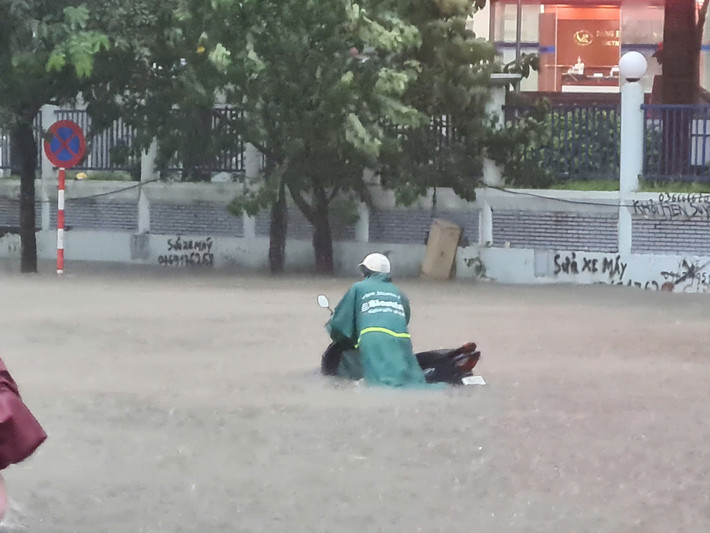 Xe chết máy phải dắt bộ do nước đã ngập quá bánh xe.