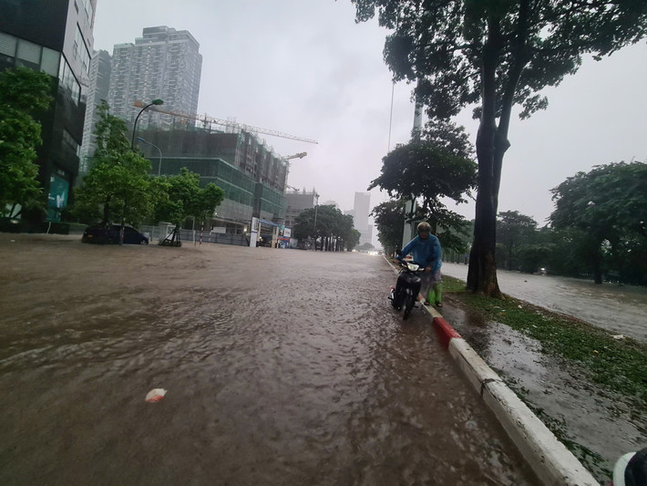 Ghi nhận của PV Báo Tri thức và Cuộc sống, lúc 7h sáng nay (7/10), tại khu vực đường Mễ Trì, Phạm Hùng, khu vực trước bến xe Mỹ Đình mực nước ngập sâu, nhiều phương tiện chết máy không thể di chuyển. .