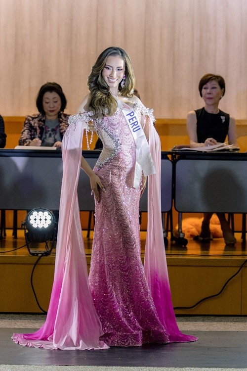 Đại diện Peru - Nathie Quijano nổi bật với đầm dạ hội tông hồng, ôm sát thân trên và xòe nhẹ ở chân váy, tà áo dài đầy thướt tha. Ảnh: Miss International.