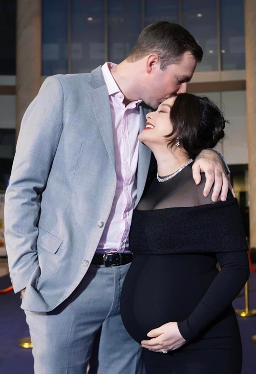 Nữ diễn viên được nửa kia hôn má khi tham gia một sự kiện trong lần mang bầu thứ 2. Ảnh: FB Lan Phương.