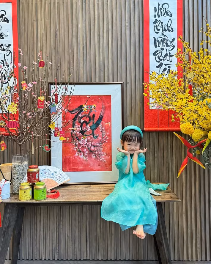 Tà áo dài giúp tôn lên vẻ đáng yêu, hồn nhiên của cô nhóc, từ ánh mắt trong veo đến nụ cười ngây thơ rất đỗi tự nhiên. Ảnh: Instagram Suchin - Sutin.