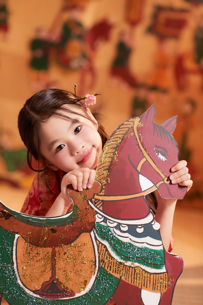 Bé Cún ghi điểm bởi nét đáng yêu khi chụp ảnh bên mô hình trang trí Tết, mang không khí vui tươi những ngày đầu năm. Ảnh: FB Tú Vi.