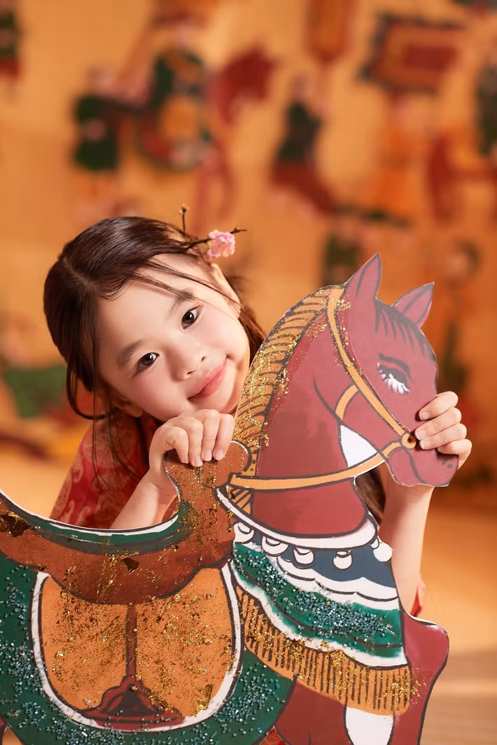 Bé Cún ghi điểm bởi nét đáng yêu khi chụp ảnh bên mô hình trang trí Tết, mang không khí vui tươi những ngày đầu năm. Ảnh: FB Tú Vi.