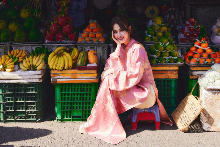 Tú Vi ghi điểm khi chọn bối cảnh chợ truyền thống, diện áo dài lụa hồng phấn với họa tiết hoa nhã nhặn, mang đậm không khí xuân miền quê. Ảnh: FB Tú Vi.