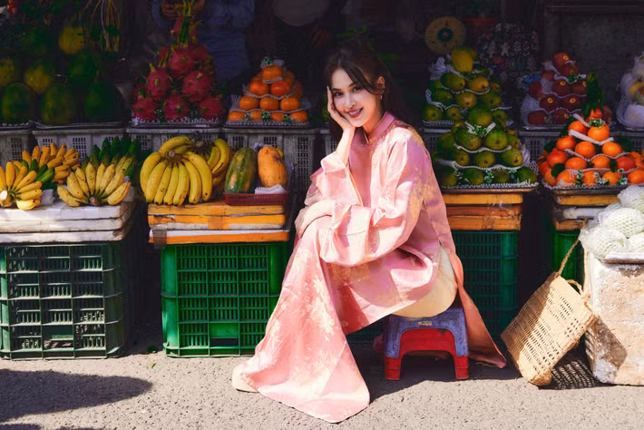 Tú Vi ghi điểm khi chọn bối cảnh chợ truyền thống, diện áo dài lụa hồng phấn với họa tiết hoa nhã nhặn, mang đậm không khí xuân miền quê. Ảnh: FB Tú Vi.