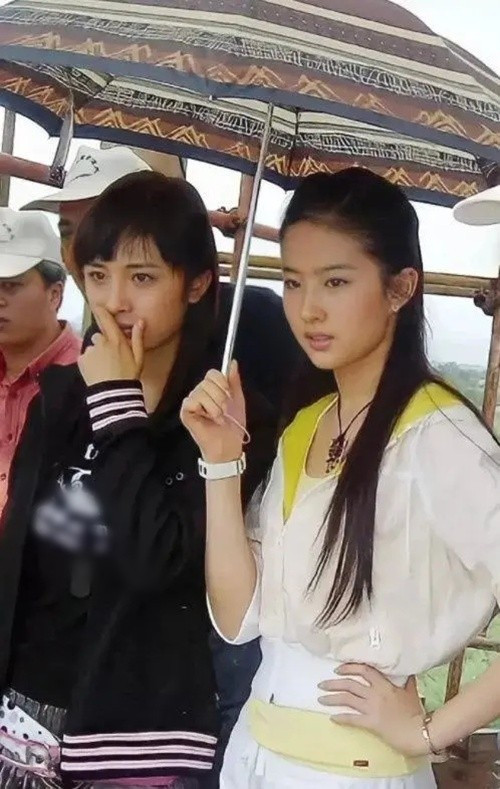 Hai nữ diễn viên thay nhau che ô cho đối phương trên phim trường Thần điêu đại hiệp. Ảnh: VTV.