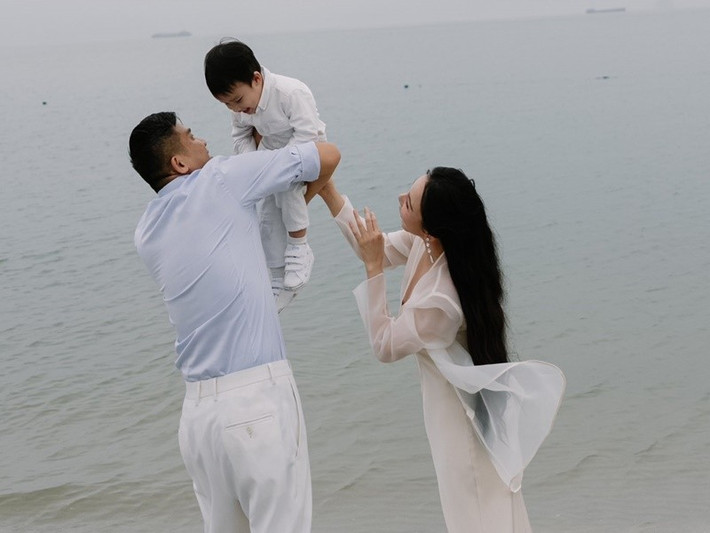 Chồng Hồ Quỳnh Hương bồng bế con trai cưng trên bãi biển. Ảnh: FB Hồ Quỳnh Hương.