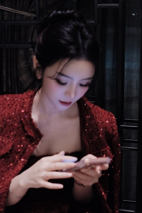 Quỳnh Kool búi tóc gọn phía sau, để lộ gương mặt thanh tú với lớp trang điểm nhẹ nhàng, nhấn vào đôi mắt và hàng mi dài.