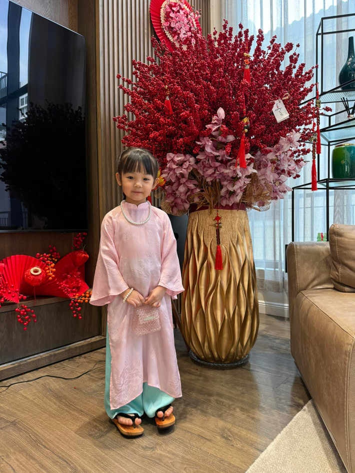 Bé Suchin diện áo dài truyền thống gam hồng pastel dịu nhẹ, chất liệu mềm mại, vừa vặn với dáng người, kết hợp quần xanh ngọc tạo cảm giác hài hòa, tươi tắn. Ảnh: Instagram Suchin - Sutin.