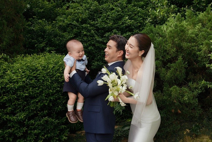 Cậu nhóc bật cười khi chụp ảnh cưới cùng bố mẹ. Ảnh: FB Hồ Quang Hiếu.