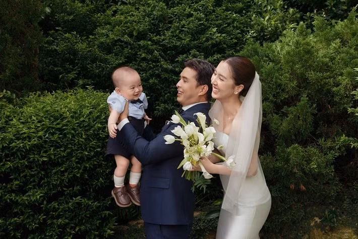 Cậu nhóc bật cười khi chụp ảnh cưới cùng bố mẹ. Ảnh: FB Hồ Quang Hiếu.