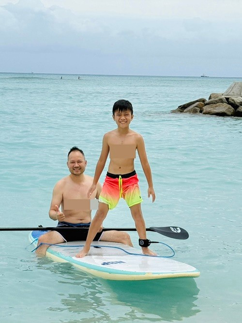 Chồng Hồng Ngọc cùng con trai út thích thú sử dụng ván lướt sóng. Ảnh: FB Hồng Ngọc.
