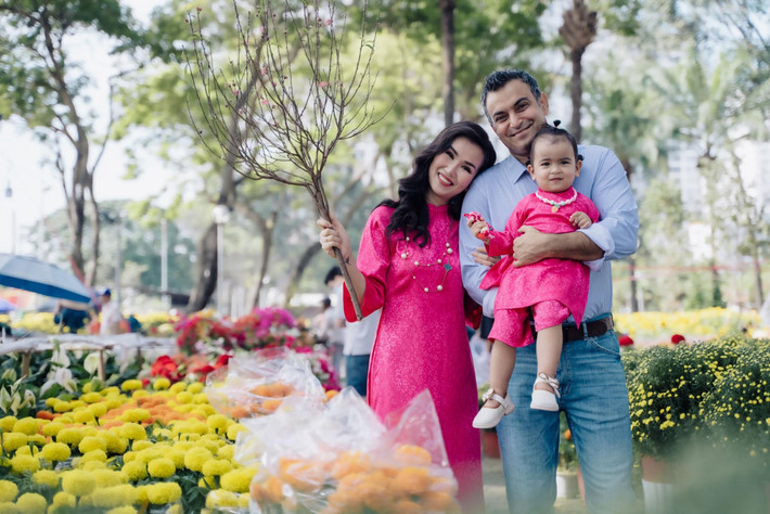 Doanh nhân Vikas Chaudhary ngại không dám nhận lì xì vì chưa hiểu về tập tục của người Việt. Võ Hạ Trâm giải thích với chồng lì xì là điều may mắn, lời chúc tốt đẹp, suôn sẻ trong năm mới. Ảnh: FB Võ Hạ Trâm.