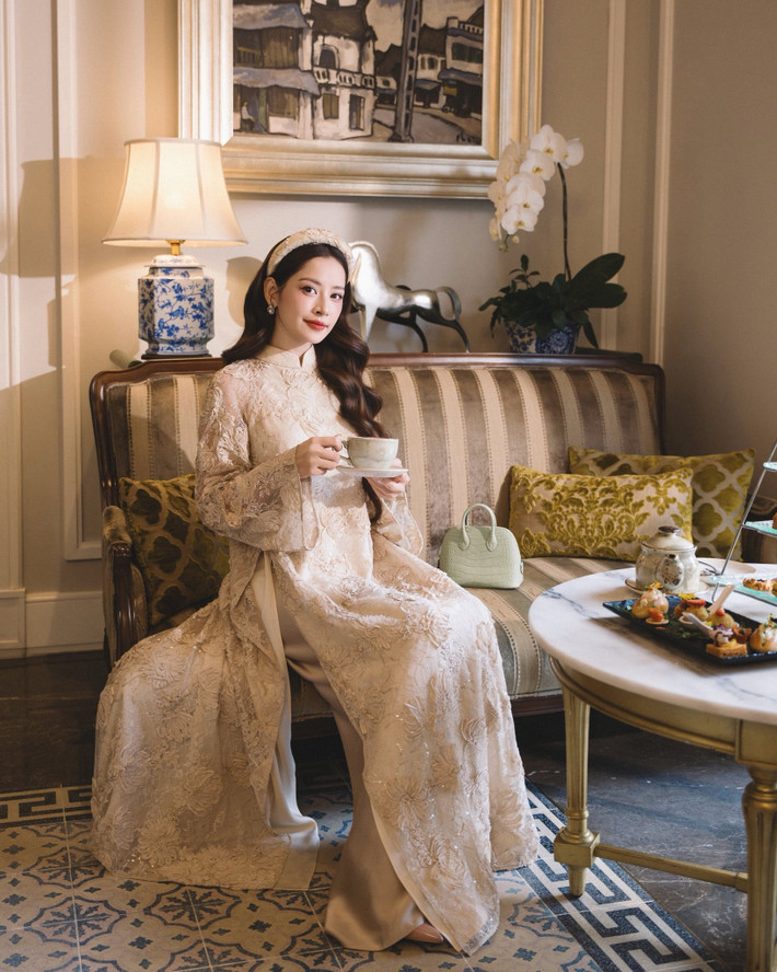 Chi Pu chọn áo dài màu kem với chất liệu ren hoa nổi, kết hợp chi tiết đính kết tinh tế, tạo nên vẻ ngoài vừa nữ tính vừa sang trọng. Ảnh: FB Chi Pu.