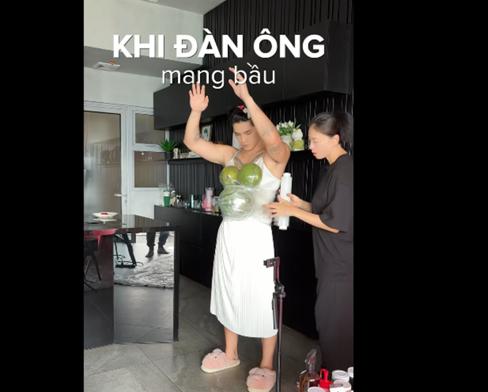Ngô Thanh Vân giúp Huy Trần mang trái cây trên ngực và bụng để thử nghiệm cảm giác mang bụng bầu vượt mặt. Ảnh: FB Huy Trần.