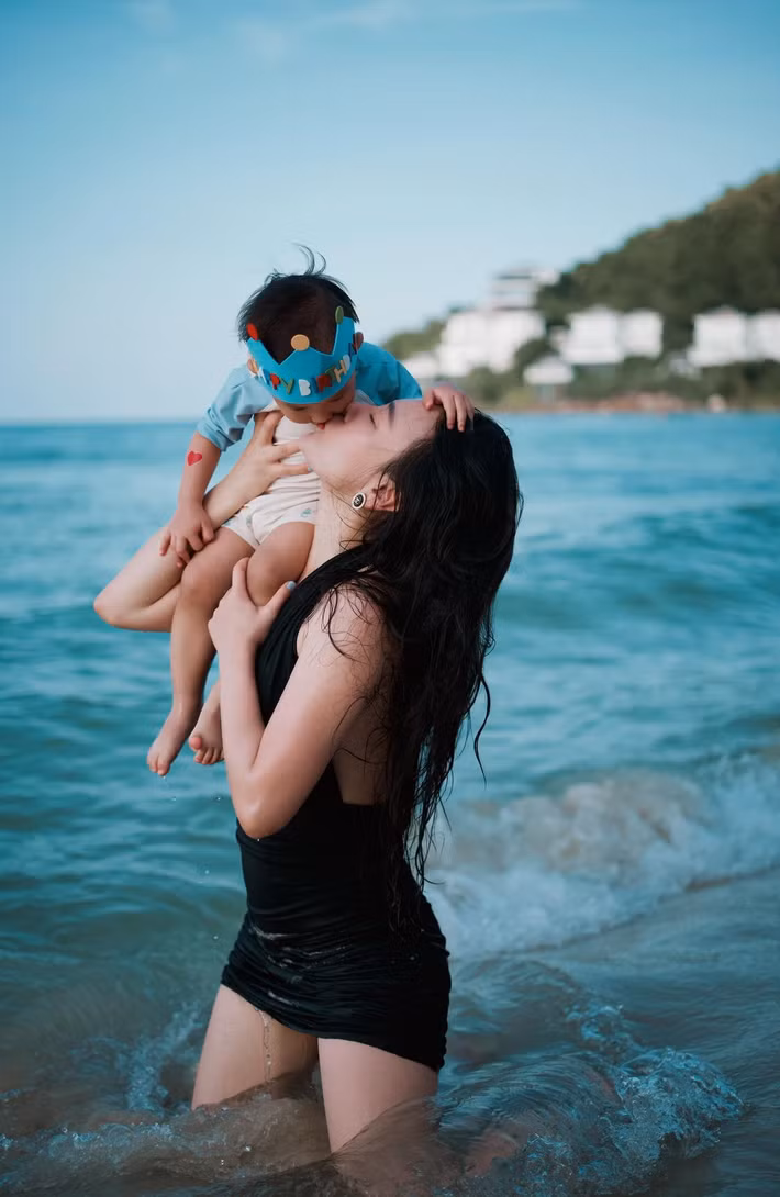 Trong loạt ảnh, Phương Oanh diện váy đen đơn giản, vui đùa cùng các con giữa khung cảnh biển xanh. Có khoảnh khắc cô ôm con trai dưới nước, có lúc nâng con gái giữa sóng biển.