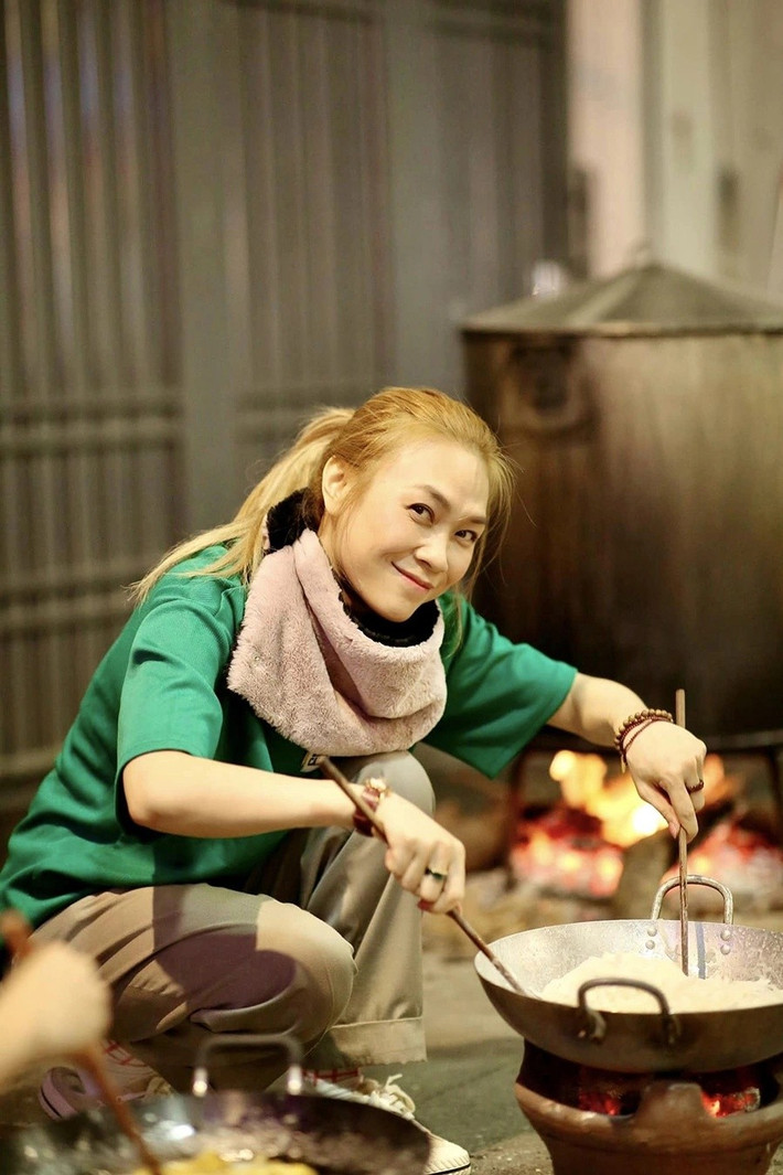 Nữ ca sĩ chăm chú đảo mứt, thỉnh thoảng dừng lại trò chuyện cùng người thân, ánh mắt ánh lên sự bình yên hiếm có sau một năm bận rộn.