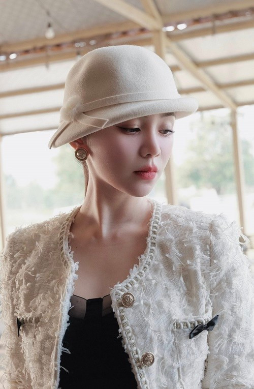 Quỳnh Kool đội mũ trắng, khoác áo tweed, toát lên vẻ sang trọng và thanh lịch.