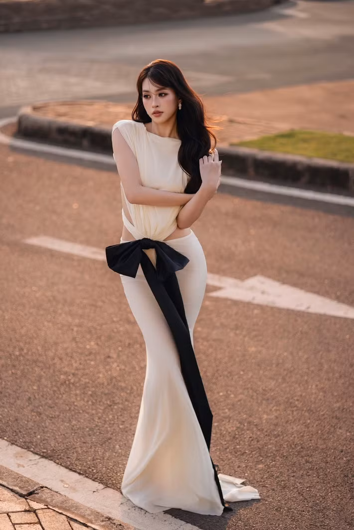Bên cạnh hình ảnh gợi cảm, Tiểu Vy còn thử sức phong cách “nàng thơ” với váy trắng dáng dài mềm mại. Thiết kế cắt khoét nhẹ cùng chi tiết nơ bản lớn giúp bộ trang phục vừa nữ tính vừa mang hơi hướng hiện đại. Ảnh: FB Tiểu Vy.