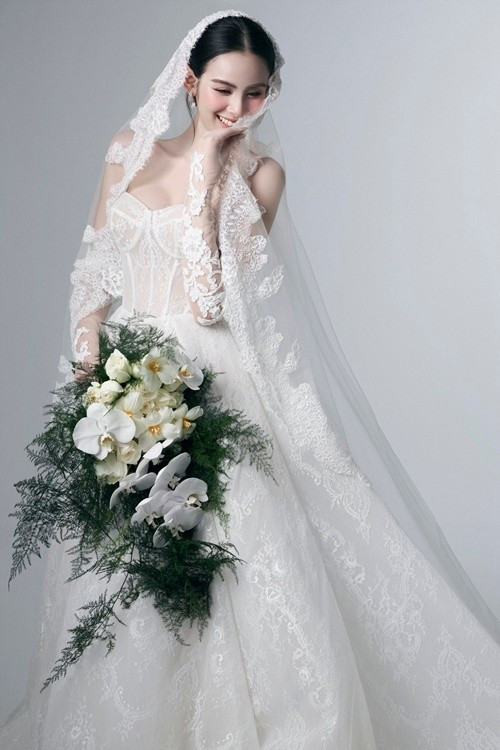 Hương Liên trang điểm tông màu cam nhạt, làm nổi bật gương mặt thanh tú. Cô chọn mẫu váy cưới ren trắng, nổi bật với chi tiết corset cúp ngực tôn dáng. Ảnh: Instagram Hương Liên.