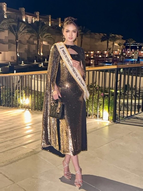 Trong một hoạt động thuộc khuôn khổ cuộc thi, Thu Ngân diện một chiếc váy dạ hội xẻ tà tinh tế giúp tôn đôi chân thon dài. Chiếc váy kết hợp cùng lớp áo choàng tông màu ánh kim, tạo cảm giác sang trọng và quyền lực. Ảnh: Instagram Thu Ngân.