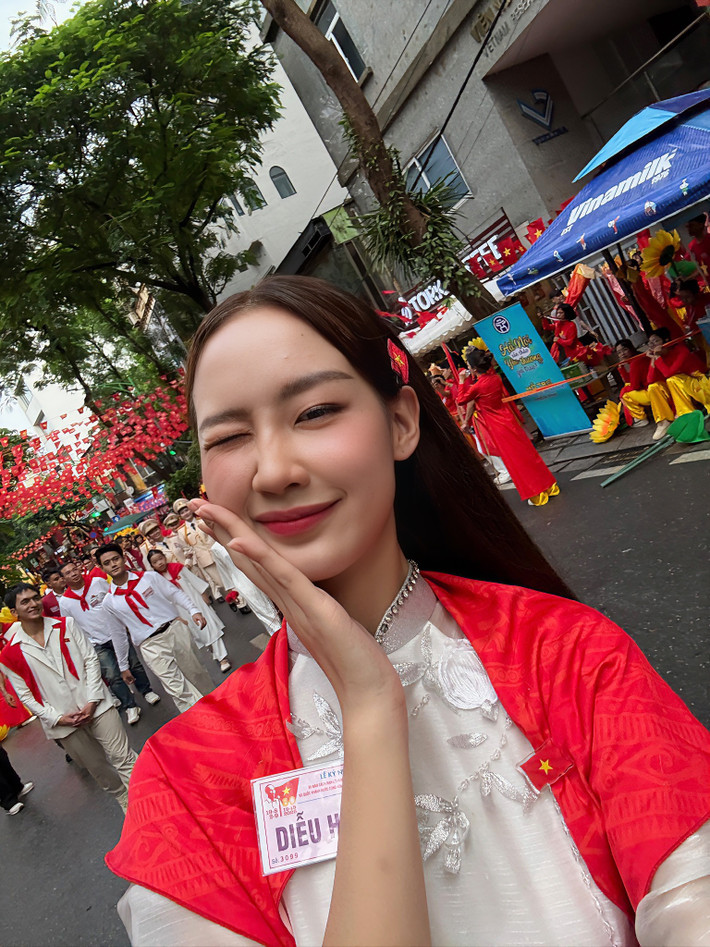 Hoa hậu Lê Nguyễn Bảo Ngọc diện áo dài trắng, khoác khăn quàng đỏ trên vai đến tham gia buổi tổng duyệt A80. Ảnh: Sen Vàng.