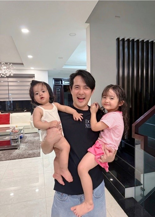 Trở về nhà sau một ngày bận rộn, Ông Cao Thắng được vợ con chào đón. "Đi làm ngày nào về cũng được 3 quý cô đón từ cửa. 1 cô tay trái, 1 cô tay phải, cô còn lại trên ngực trái đang chụp ảnh", Ông Cao Thắng viết trên trang cá nhân. Ảnh: FB Đông Nhi.