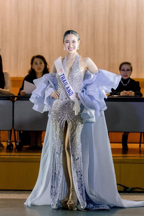 Jarupiya Boribalburibhand - đại diện Thái Lan khoe vẻ gợi cảm ở bán kết trong phần thi trang phục dạ hội. Người đẹp chọn mẫu váy xẻ tà cao, nổi bật với chi tiết áo choàng và tay bèo nhún màu xanh nhạt, mang lại vẻ ngoài vừa sang trọng vừa quyến rũ. Ảnh: Miss International.